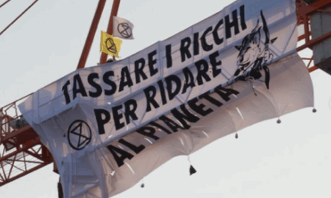 Matrimonio Bezos, attivisti appendono uno striscione su una gru: “Tassare i ricchi per ridare al pianeta”